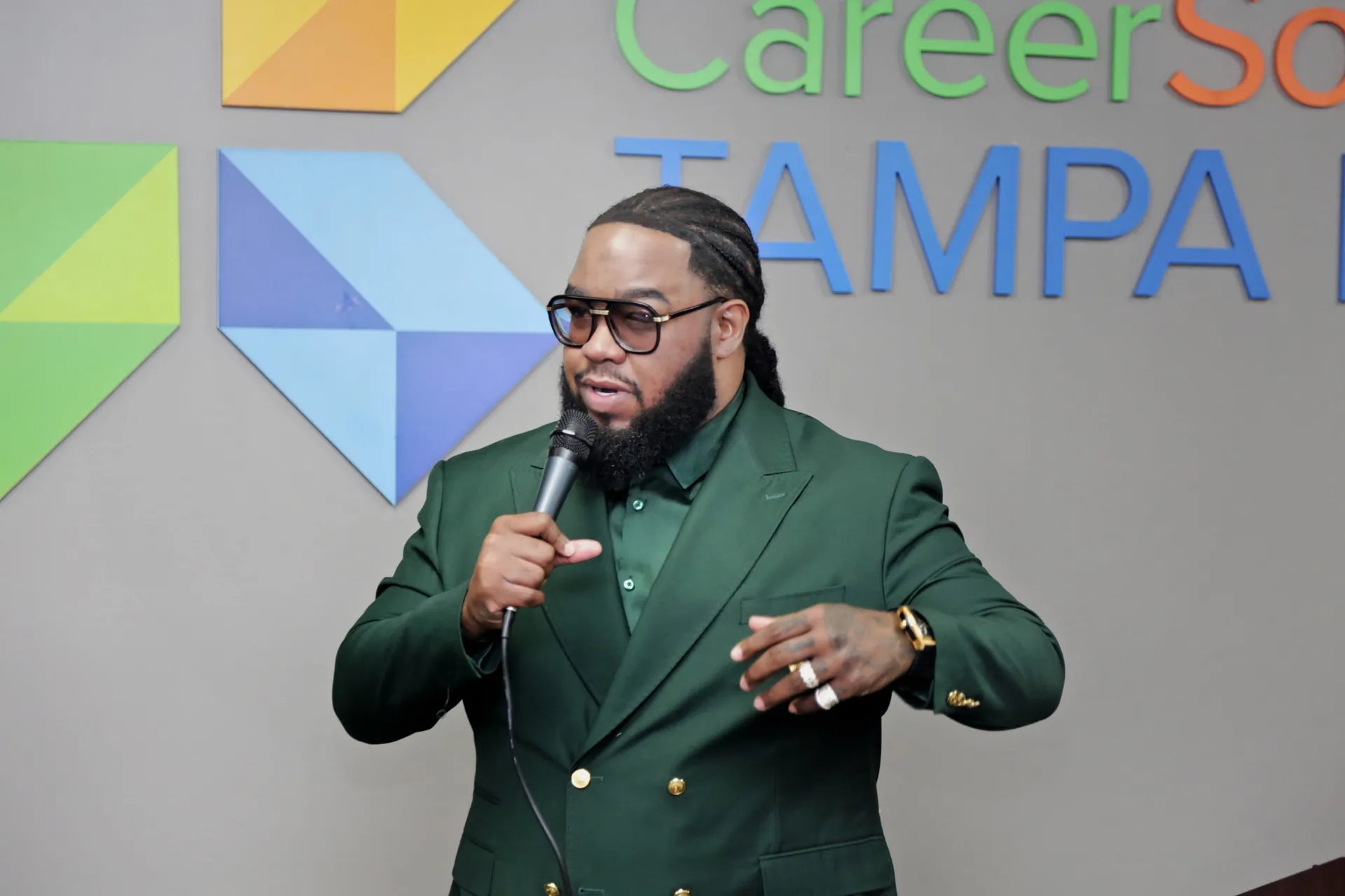 Taj Mahal in a green suit holding a microphone at an event in Tampa, video reel